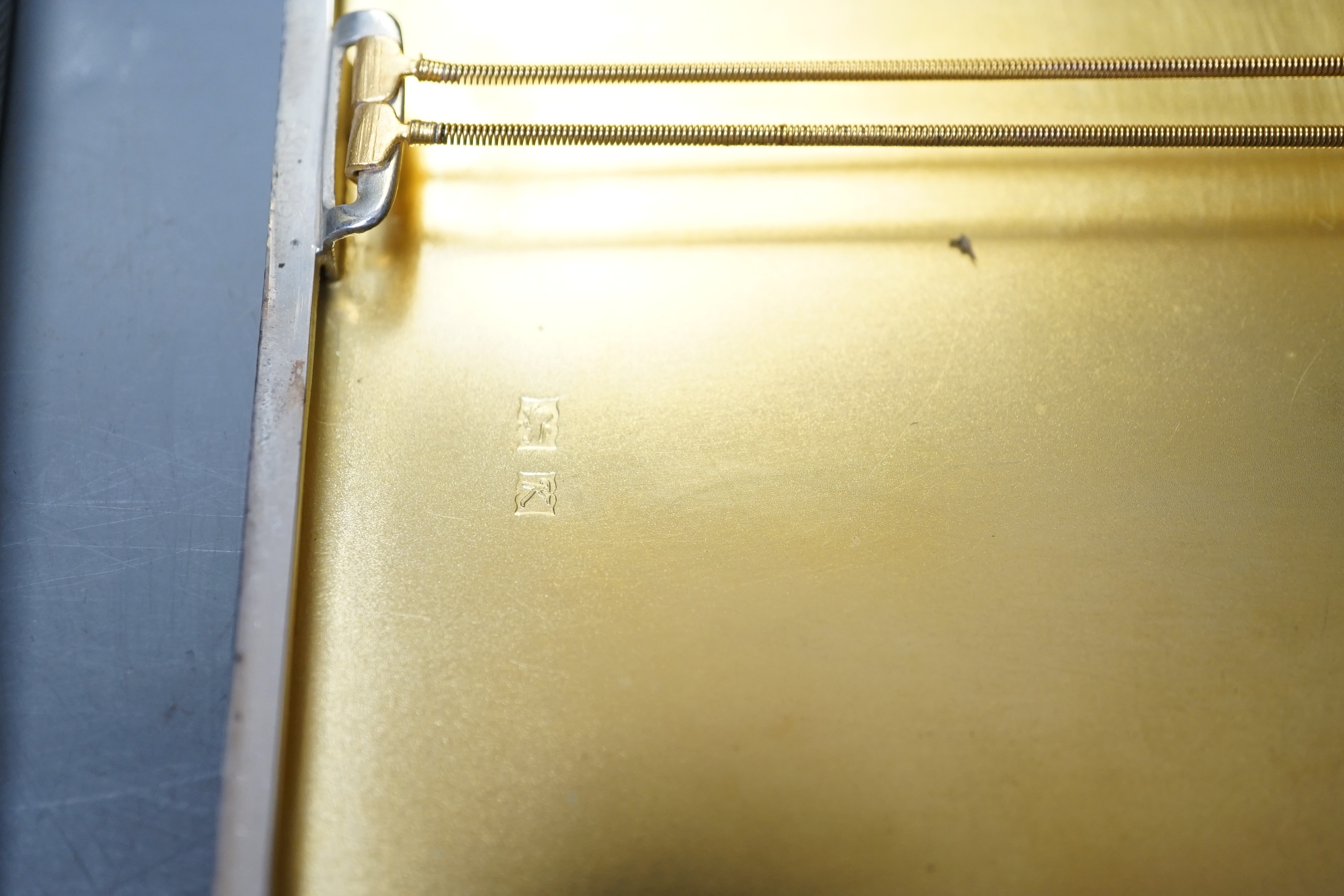 A George VI engine turned silver rectangular cigarette box/case, engraved with a squirrel, W.H. Manton Ltd, Birmingham, 1942, 12.2cm, one other Mappin & Webb silver cigarette case and a continental white metal snuff box.